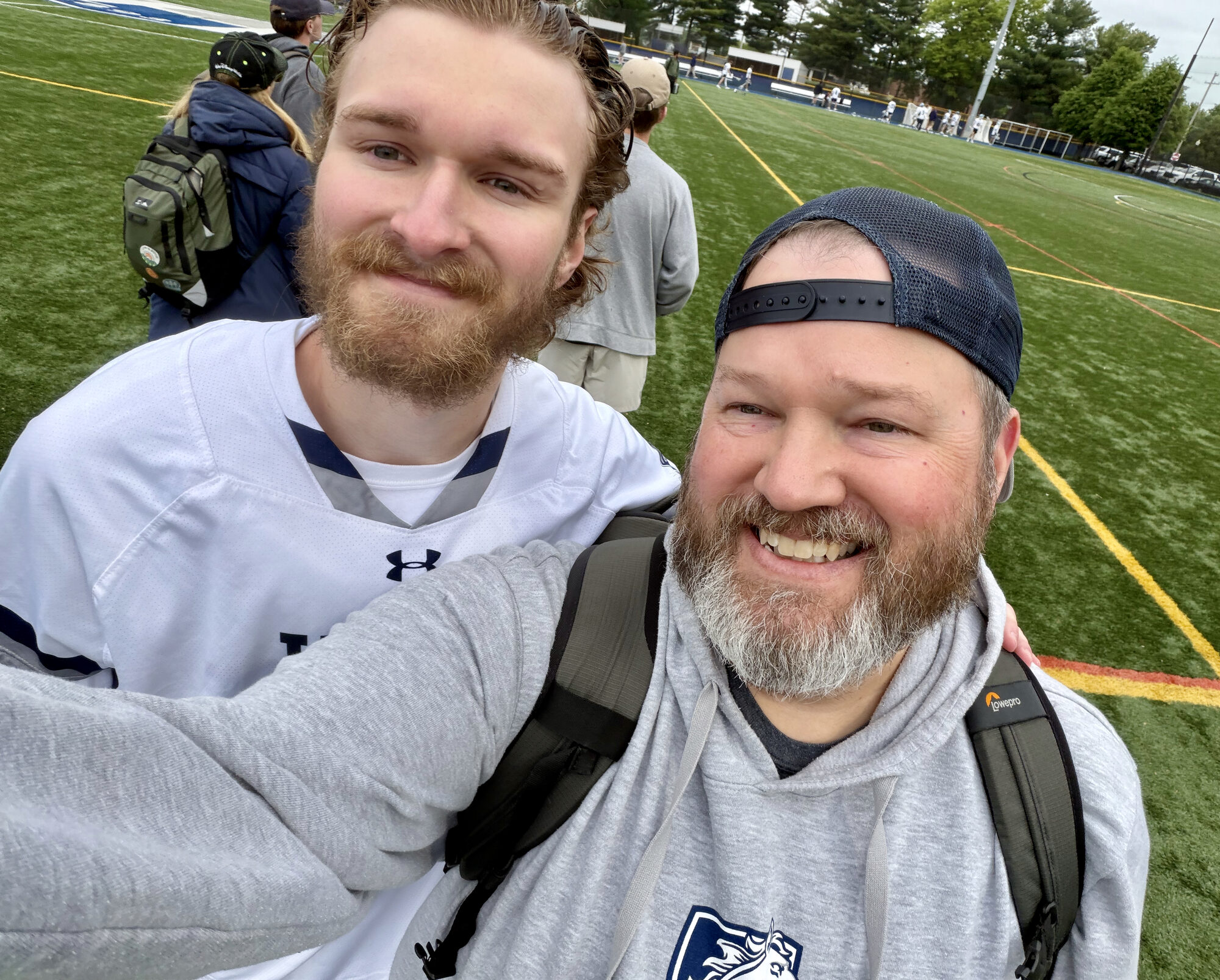 Gerald and Jack together on the sideline at a lacrosse field