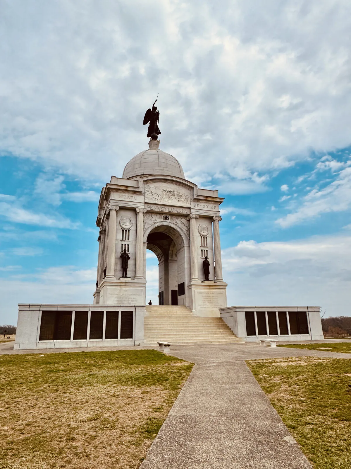 The domed Pennsylvania Memorial at Gettysburg beneath a bright blue sky streaked with clouds