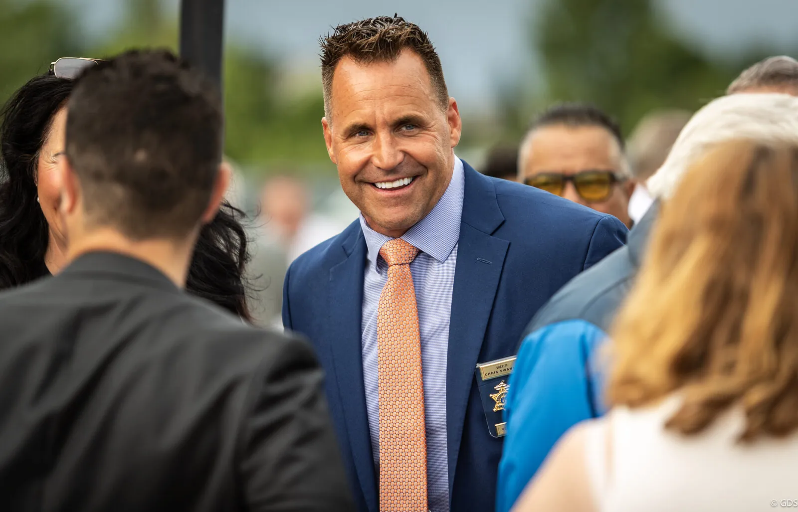 An official greeting supporters at a summer campaign event