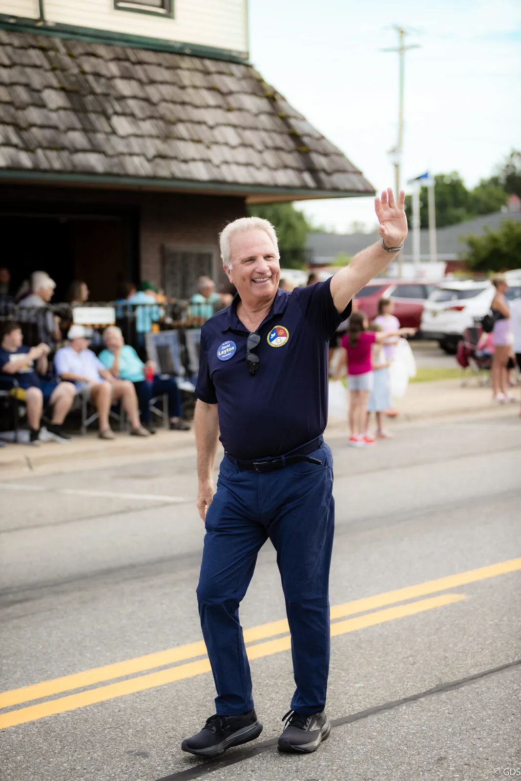 Genesee County Prosecutor David Leyton waving to the crowd while walking the Clio 2024 parade