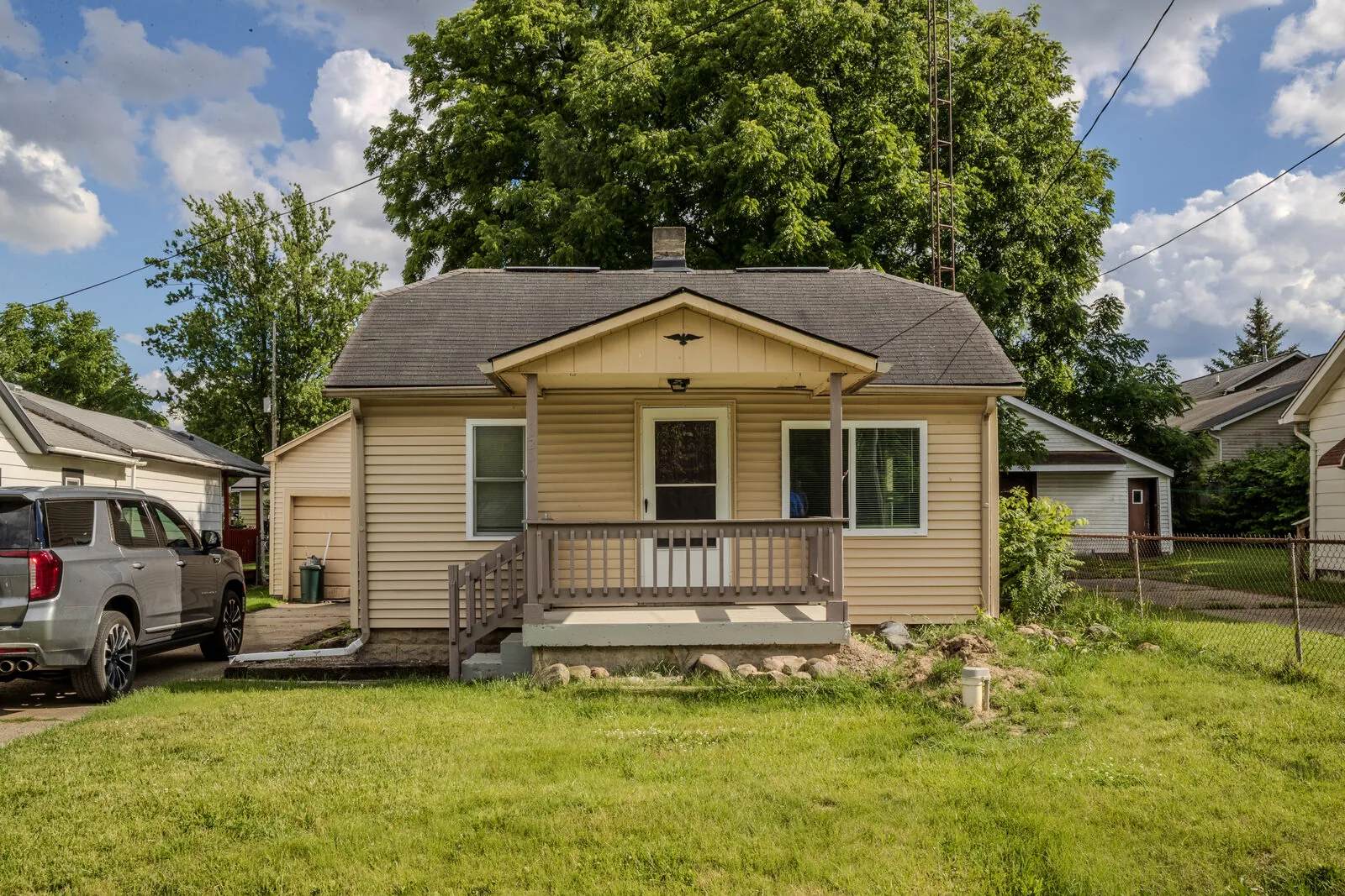 Exterior of a tan bungalow with a covered front porch — 1121 W. Boatfield, Burton