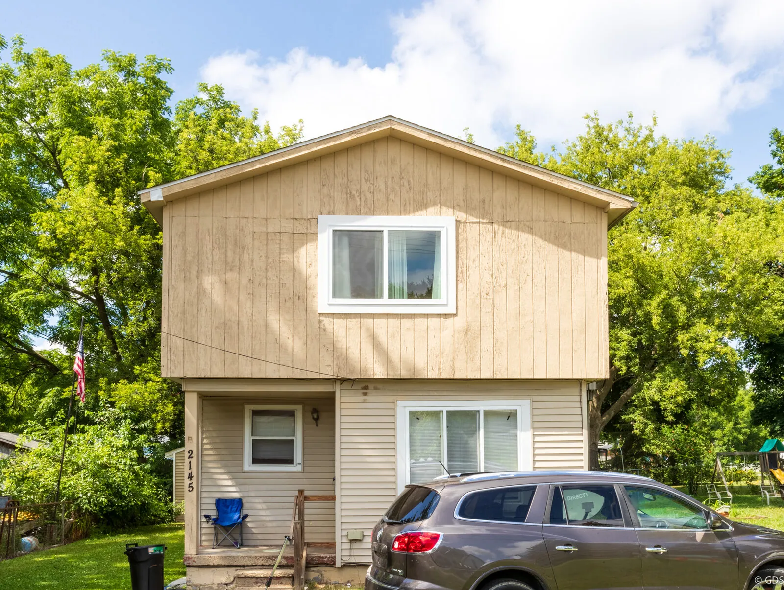 Two-story rental home with a parked car out front — 2145 E. McLean St., Burton