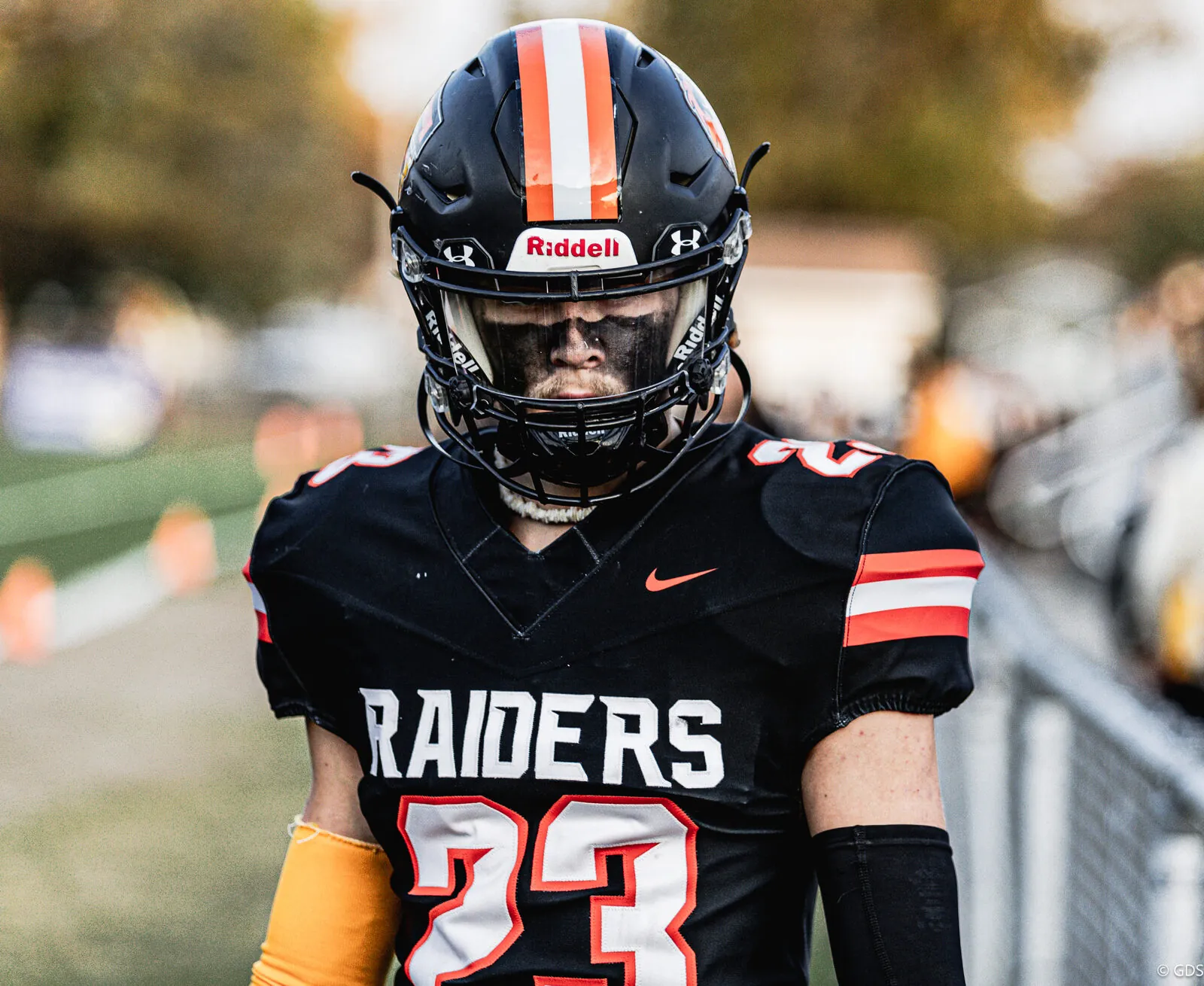 High school football — a Flushing Raiders player heads onto the field at dusk