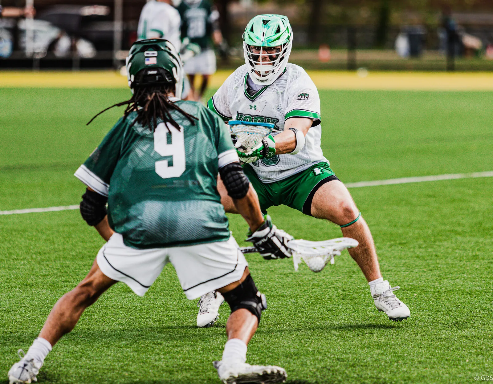 College lacrosse defender pressuring a ball-carrier during the MAC championship