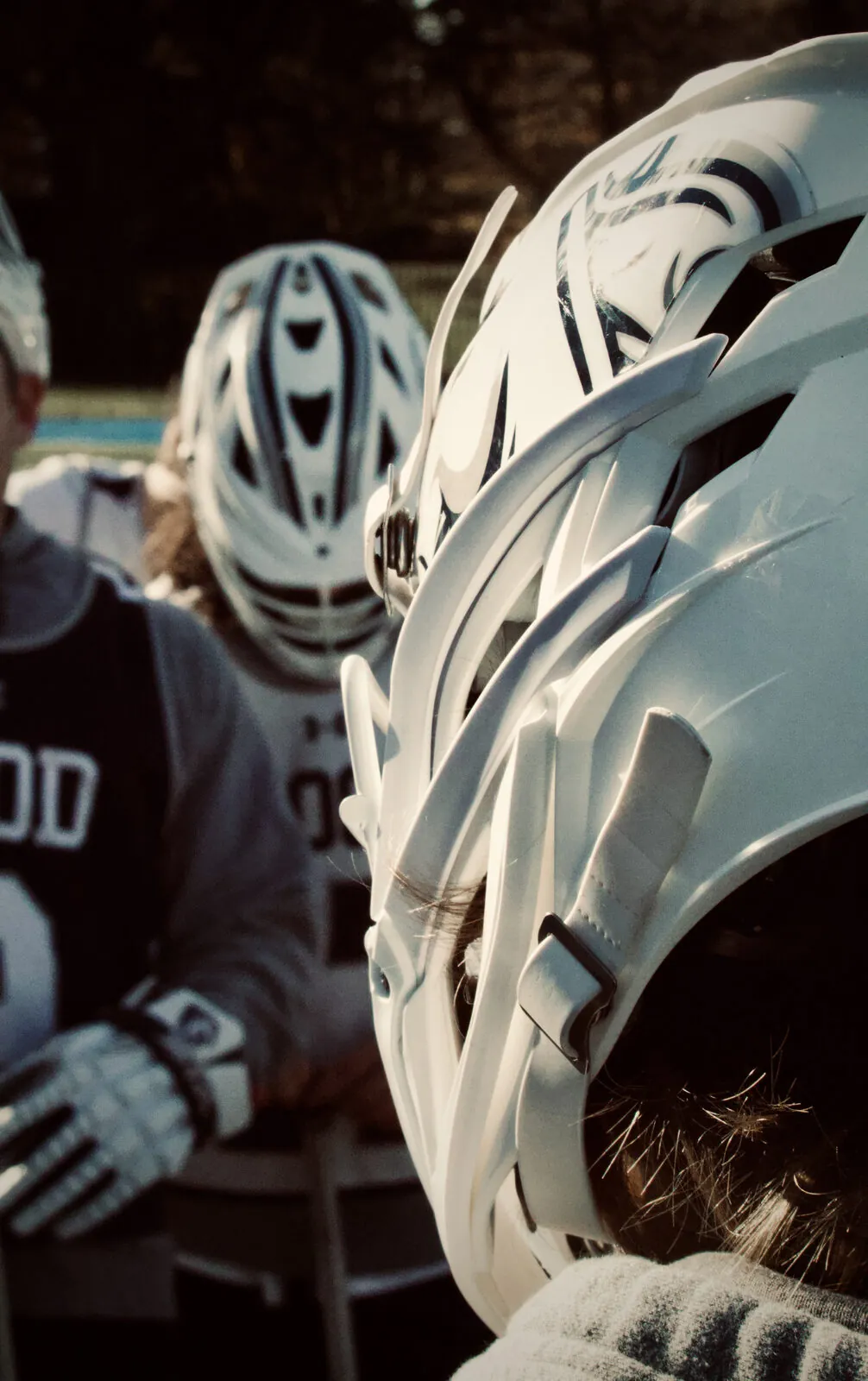 Close-up of Hood College lacrosse helmets in warm sideline light