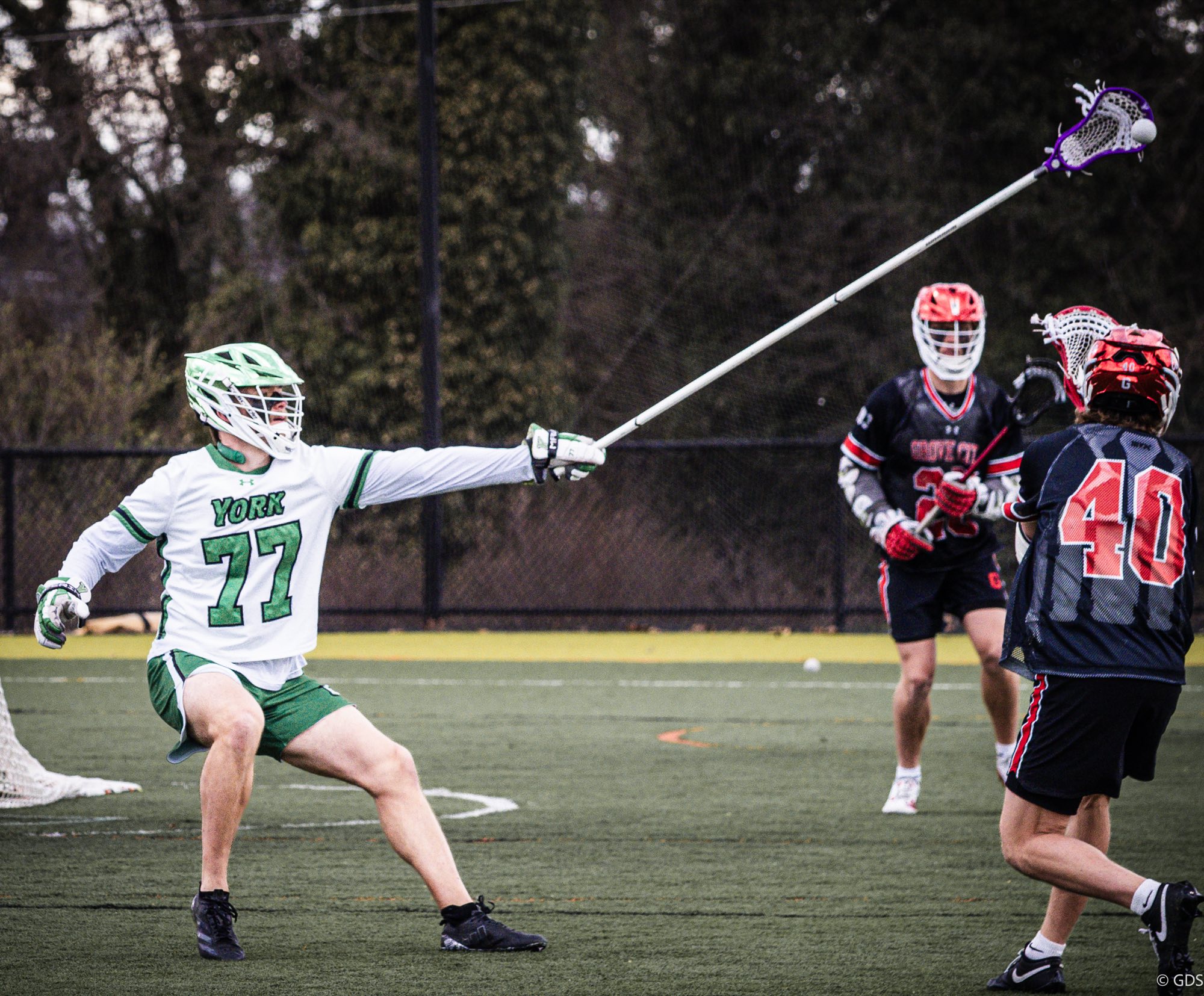 Trey Snodgrass in his white York uniform at full one-handed extension, knocking a pass out of the air as two defenders close in